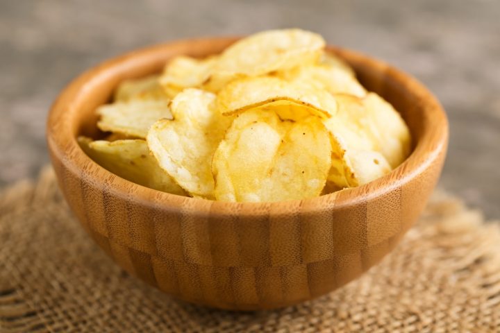 Hearty potato crisps served in a wooden bowl.